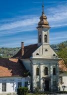 Beautiful and colorful church among the plants, in Esztergom, Hungary, under the blue sky with white clouds