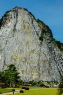 Beautiful landscape with Golden Buddha on the mountain, among the colorful plants, at Silverlake, in Thailand, under the blue sky