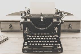 vintage black typewriter with white keys on the table