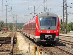 red electric train on rails on a sunny day