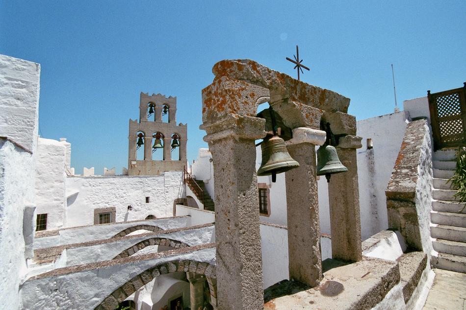 Beautiful church bells, among the buildings in Greece, at blue sky on background b