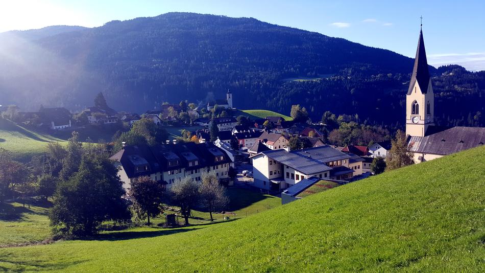 Beautiful village on the green mountains with trees, with the church