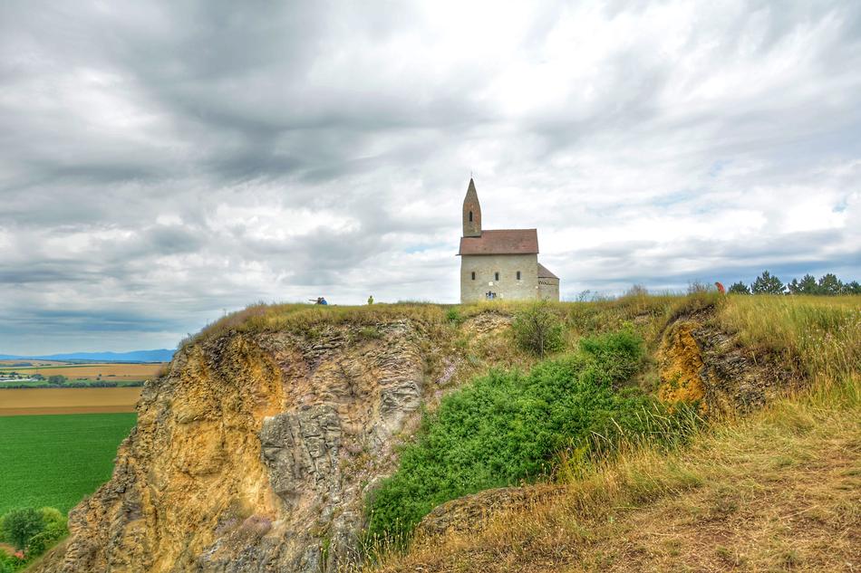 Beautiful church, among the green and yellow fields, under the cloudy sky in Slovakia