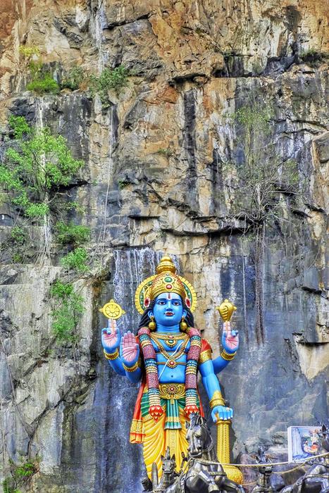 Beautiful and colorful Hindu statue near the rocks