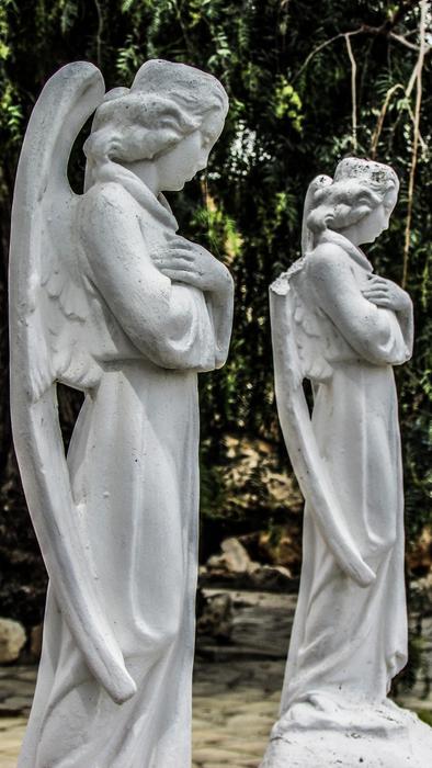 statues of angels in prayer in the garden