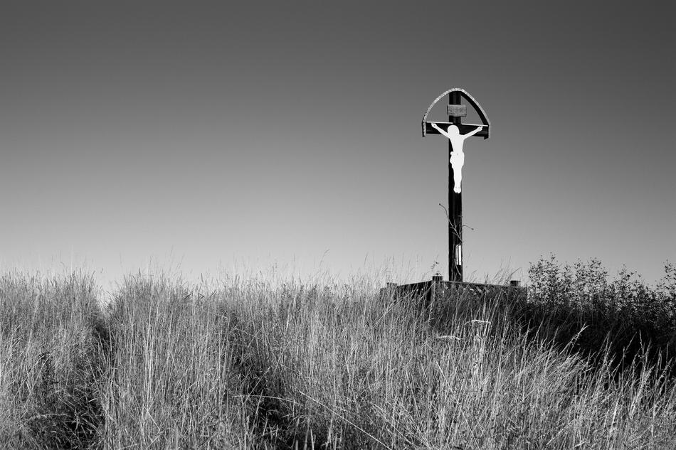 monochrome photo of Jesus Crucifixion Wayside on meadow