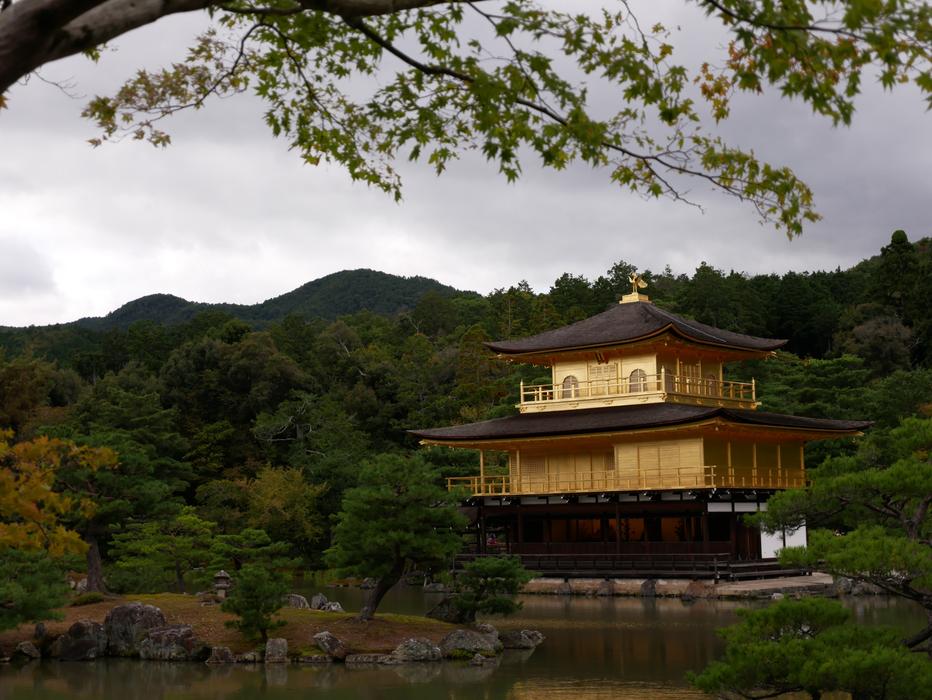 Beautiful temple, near the water, among the colorful trees, in Japan, under the cloudy sky