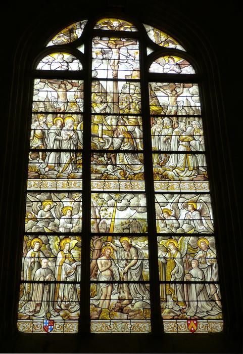 View of the beautiful and colorful stained glass window in Burgundy, France, among the shadows