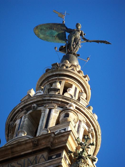 sculpture on the steeple of the church against the blue sky