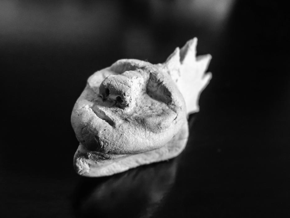Black and white photo with the close-up of the ancient mask with reflection