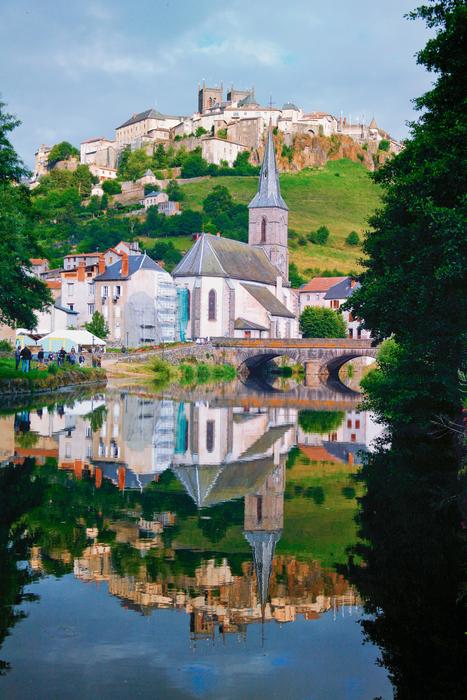 Beautiful and colorful Saint-Flour near the water, among the colorful plants
