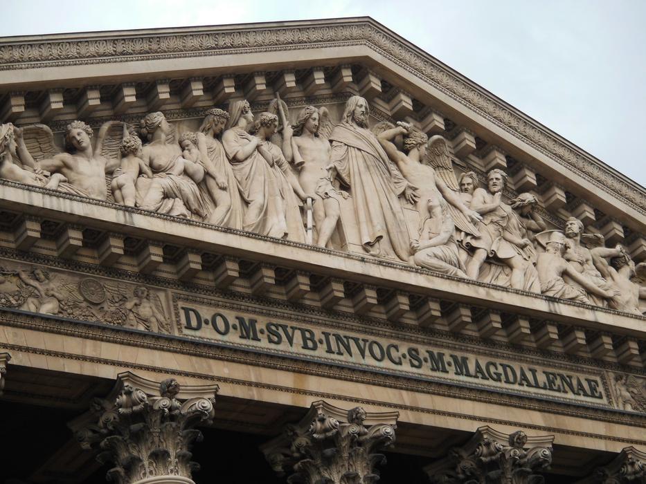 Beautiful statues on the building with columns, in Paris, France