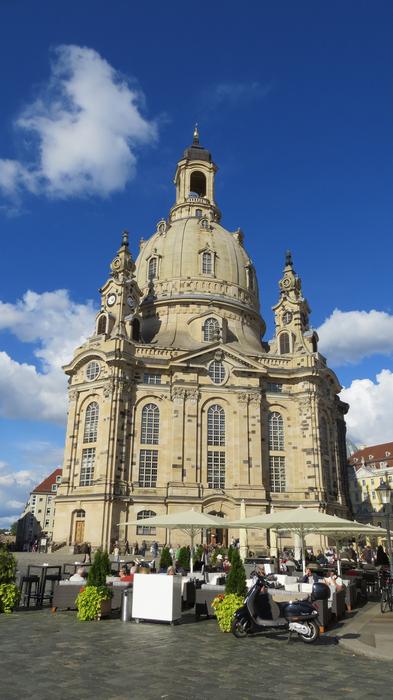 tourists and Frauenkirche on a background of blue sky and clouds