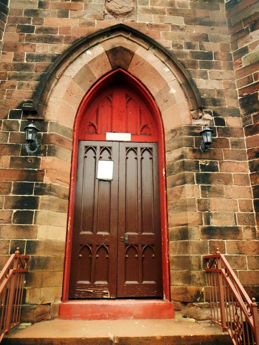 Beautiful, wooden door with arch of the colorful church
