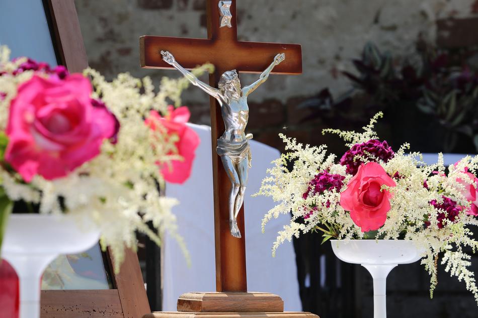 pink roses near the crucifix on a blurred background