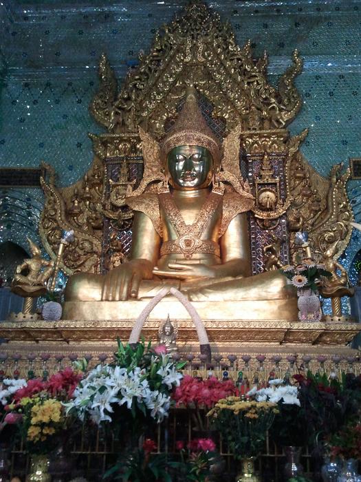 flowers in front of a buddha in a temple