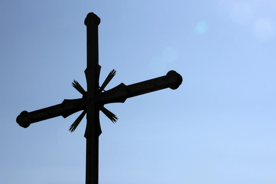 dark christian Cross at blue sky