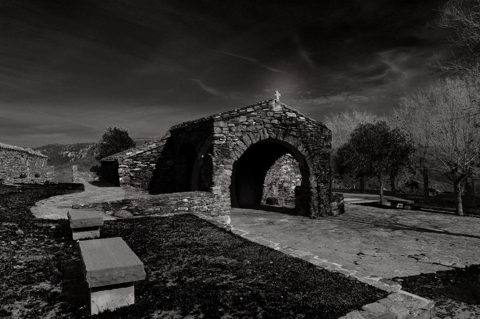 Black and white photo of the beautiful church in Ussassai, Sardinia, Italy, among the trees