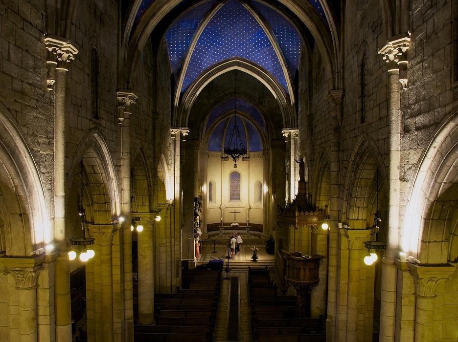 people walking in dark interior of impressive gothic cathedral, France