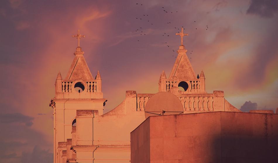 Beautiful church with the cross, at colorful and beautiful sunset, with clouds
