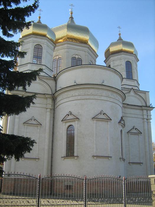 Beautiful Komsomolskaya Hill monastery with gold domes, in Stavropol, Russia, near the tree, under the blue sky