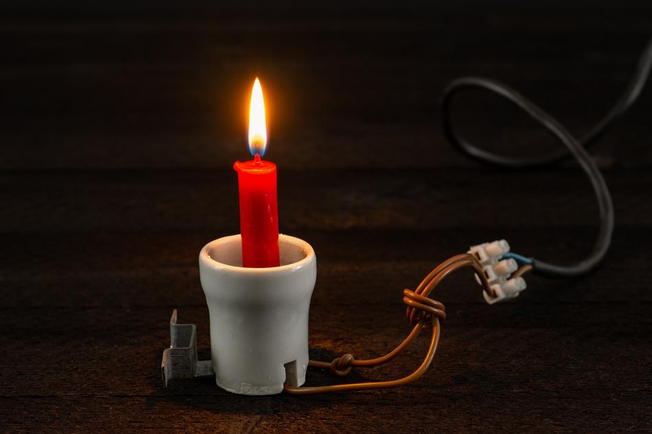 Beautiful, burning red candle in the white porcelain, with the wire