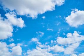 white fluffy clouds in the blue sky in summer