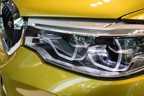 headlight of a yellow shiny car