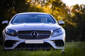 Mercedes Benz, luxury Silver car on grass at sunset