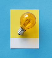 light bulb on yellow postcard on blue background