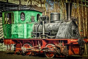 Beautiful, retro, green, black and red, retro locomotive on the railway