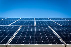 panoramic photo of solar panels against a blue sky