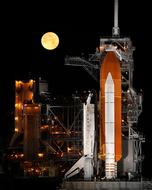 NASA space shuttle on launch pad against the backdrop of the full moon