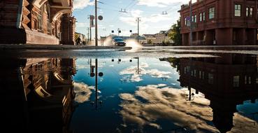 reflection of urban architecture in a large puddle