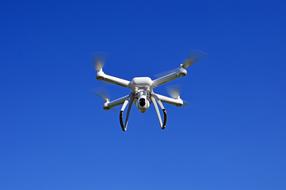 white drone against the blue sky