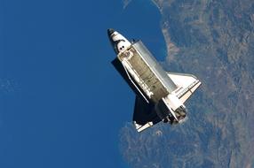 Atlantis Space Shuttle in flight above earth planet