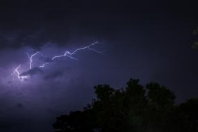 flash of lightning in the stormy sky over the forest