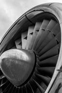 Black and white photo with the close-up of the shiny turbine of the aircraft, with the propeller