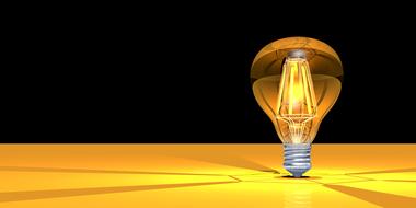 yellow light bulb on black background