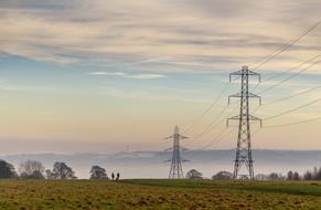 high voltage power lines in the field at dusk