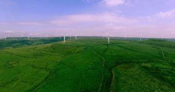aerial photography of a wind park in a green field
