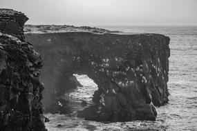 black and white wallpaper with a rock in the sea