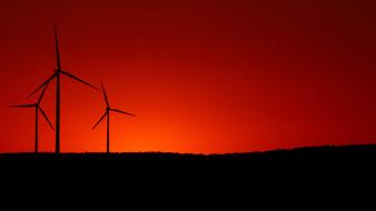 wind turbines on a hill on a background of red sunset