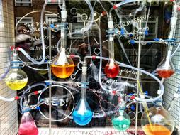 flasks with paints of different colors on the shop window