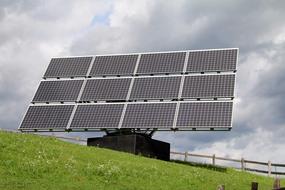 solar panels on the side of a green hill