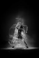 Black and white image of the person dancing among the smoke