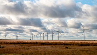 windmills on a field under the clouds in texas