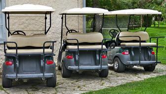 golf cars are parked on the edge of the court