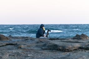 photographer with a tripod by the sea