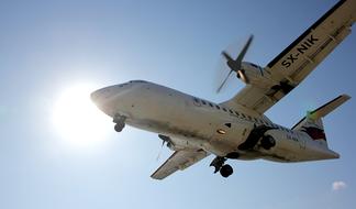 Flying aircraft at blue sky background with Sun